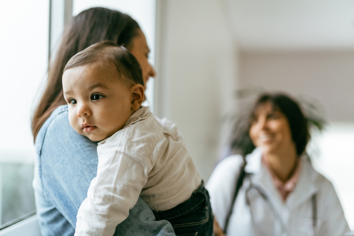 mother holding a baby at a doctor's office